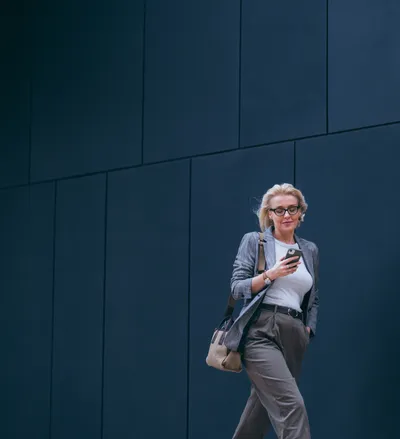 Beautiful Businesswoman Walking to Her Work Office and Reading a Message on Her Mobile Phone